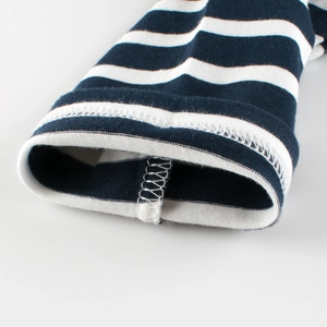 Gros plan sur le poignet en coton rayé bleu et blanc avec finitions de couture soignées
