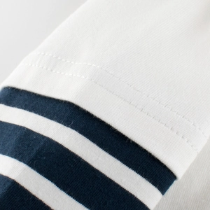 Détail de couture sur t-shirt en coton pour garçon avec rayures blanches et bleues