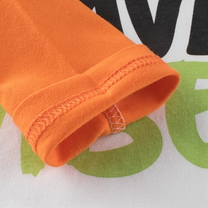 Close-up of cotton long sleeve T-shirt with orange cuffs and large letter print detailing