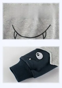 Detail of monster print on grey fabric and navy ribbed cuffs with eye embroidery