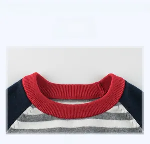 Detail of red ribbed crew neck and navy sleeve on striped knit sweater for children