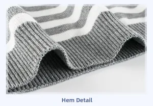 Macro detail of the grey and white striped ribbed hem on a boy's knitted sweater