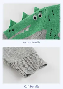 Detail of dinosaur embroidery with 3D fins and elastic ribbed cuffs on knit sweater