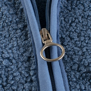 Close-up of navy blue fleece jacket showing fluffy texture and round metal zipper pull