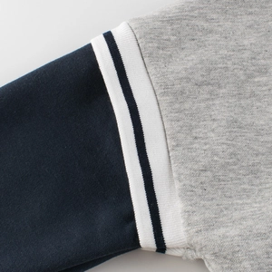Close-up of boys knit sweatshirt with navy white and grey patchwork sleeve cuff details