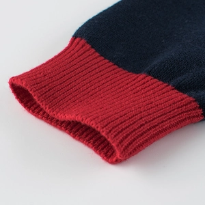 Navy blue kids knit sweater with red ribbed cuffs showing detailed knit texture