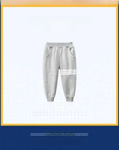 Close-up of gray kids sports joggers with elastic waistband and white side stripes