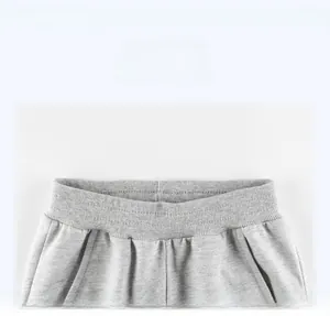 Detail of grey knitted joggers showing elastic ribbed waistband and side pocket