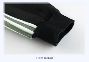 Détail du bord-côte du pantalon de sport enfant avec bandes latérales vertes et blanches