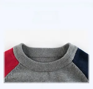 Gros plan d'un pull tricolore pour garçon montrant l'encolure en maille côtelée et les détails