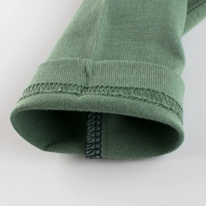 Close-up of green knit long sleeve ribbed cuffs with neat overlock sewing for boys