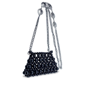 Detail of hand-woven black beaded mini bag with sun-textured silver chain metal charms