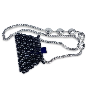 Close-up of handmade black beaded handbag featuring a decorative silver chain strap