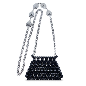 Detail of black beaded mini crossbody bag with silver metal chain and vintage relief charms