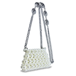 Close-up of handmade beaded mini pearl bag with silver chain and vintage metal charms