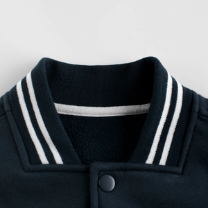 Detail of navy baseball jacket with ribbed striped collar and inner fleece lining
