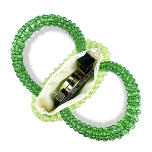 Detail of green beaded handbag interior showing zipper pocket and makeup storage space