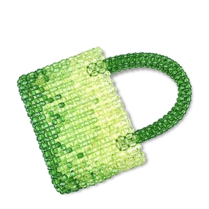 Close-up of handmade beaded handbag with gradient green beads and woven texture