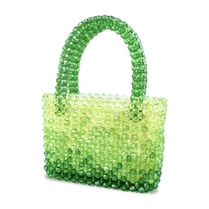 Detailed close-up of a beaded handbag featuring a stylish green gradient weave design