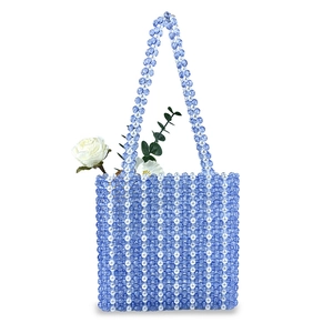 Détail d'un sac cabas tissé main avec perles en acrylique bleu et fausses perles
