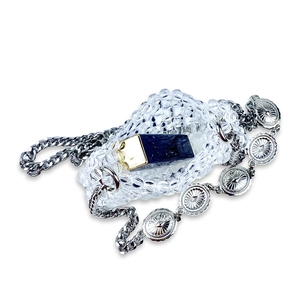 Detailed view of handcrafted crystal bead mini bag with pearl chain and sunburst metal charms