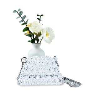 Detail of handmade beaded mini bag with silver chain strap and floral background