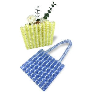 Détail de sacs à bandoulière tissés à la main en perles acryliques jaunes et bleues