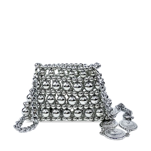 Detailed view of silver metallic beaded handbag with retro industrial chain and medal