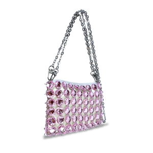 Macro detail of hand-woven pink crystal beads on a white fabric base handbag
