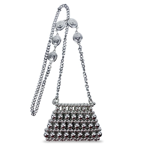 Detail of silver beaded mini bag with metallic sun-patterned decorative discs on chain