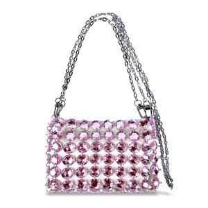 Detail view of pink crystal beaded evening bag with silver chain strap and white satin base