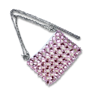 Detailed macro of pink beaded crystal handbag with silver chain and white zipper