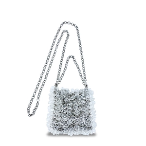 Detail of transparent ruffles and silver chain strap on clear acrylic evening clutch bag