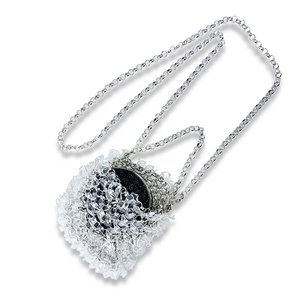 Close-up of wavy acrylic bead bag with silver chain and blue glitter disc detail