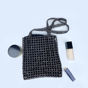 Détail du sac à bandoulière gris perlé fait main avec motif creux tissé et texture unique