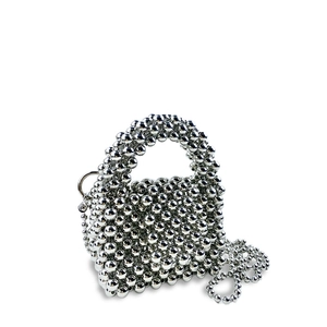 Dettaglio borsa a mano argento con perline metalliche e tracolla rimovibile