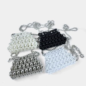 Detailed shot of four beaded mini handbags in pearl, black, silver, and clear styles