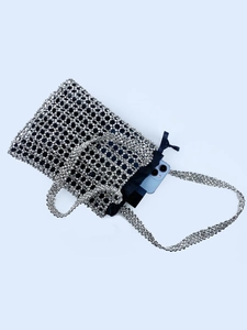 Détail macro du sac à bandoulière argenté perlé montrant la capacité pour le téléphone
