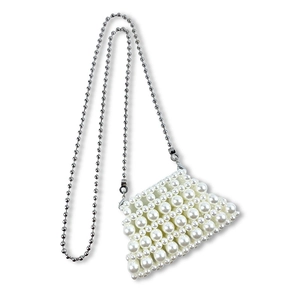 Detail of white pearl beaded mini bag with elegant silver metal spherical chain strap