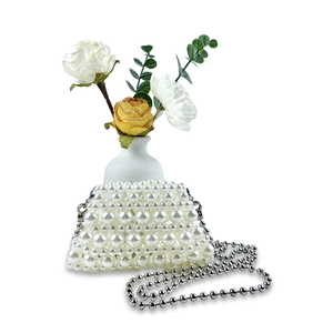 Detailed view of handmade pearl beaded evening bag with silver metal ball chain