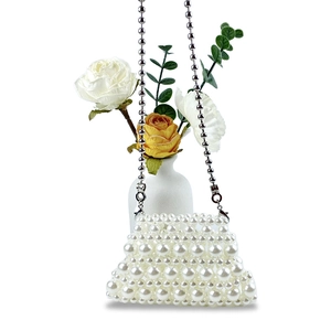 Detailed view of mini white pearl beaded bag with elegant silver metal chain strap