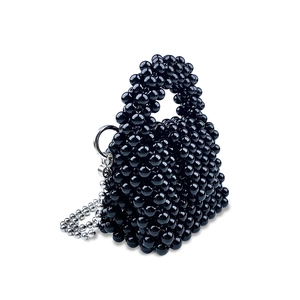 Dettaglio mini borsa nera di perline con superficie strutturata e catena argento