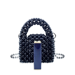 Dettaglio di mini borsa di perline nere con catena argento e rossetto come riferimento
