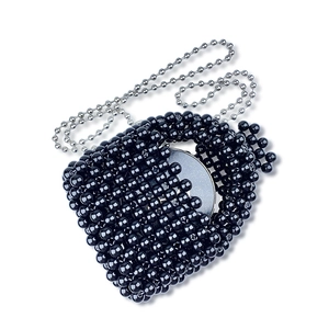 Dettaglio mini borsa nera di perline fatta a mano con catena d'argento e specchio interno