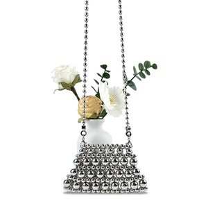 Macro view of metallic beaded mini bag featuring shiny silver beads and pearl chain strap