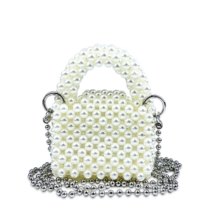 Dettaglio mini borsa a mano artigianale di perle bianche con tracolla a catena d'argento
