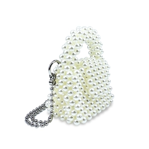 Dettaglio della mini borsa in perle bianche intrecciate con catena argento e manico