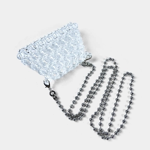 Detailed macro of a clear beaded mini bag featuring a sleek silver ball chain strap