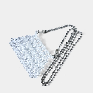 Detail of hand-woven clear beaded mini bag with silver metal ball chain and lobster clasp