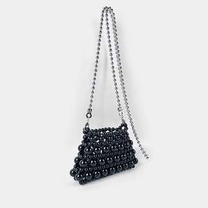 Detail of black pearl beaded crossbody bag with silver ball chain and trapezoid shape